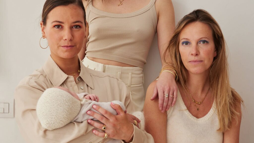 Trois jeunes mamans en post-partum, l'une portant son bébé — holi-mama