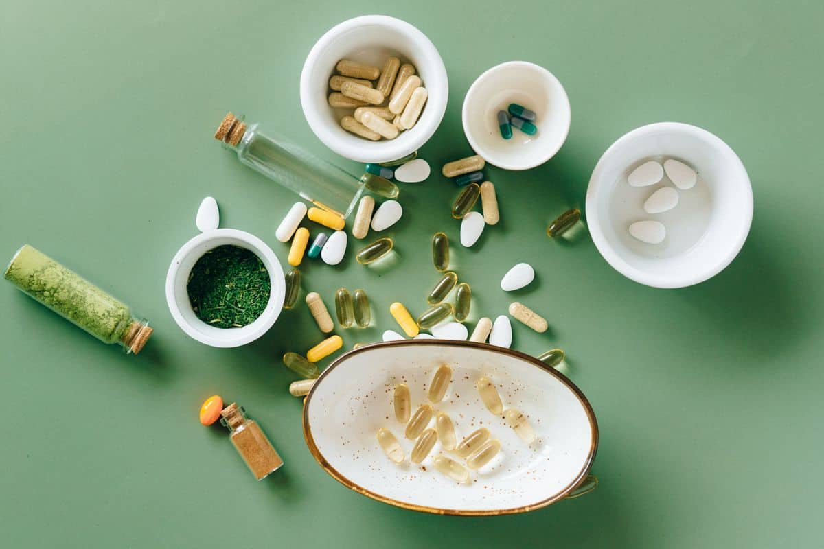 Gélules et comprimés de compléments alimentaires dans de petits bols